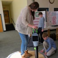 <p>John Jay Middle School seventh-grader Peter Gressler, right, helps a fellow student operate the “hoverboard” he created for the school’s science fair.</p>