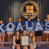 <p>Members of the Ursuline School&#x27;s Junior Varsity Cheerleading Team holding team mascot sign and the commendation certificate they received from the New Rochelle City Council.</p>