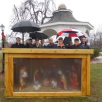 <p>Members of the St. John XXIII Council 5987 of the Knights of Columbus at St. Jude gather under umbrellas Sunday to bless a Creche placed on the Monroe Town Green.</p>