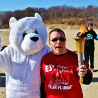 <p>A participant holds a torch at Lake Welch in Stony Point during Freezin&#x27; for a Reason.</p>