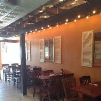 <p>Wood beams, tin roof and strings of lights provide ambiance for diners.</p>