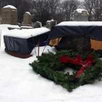 <p>Locals laid wreaths at the graves of veterans in the December ceremony -- including this vandalized one, which has been covered to prevent further damage, pending repair.</p>