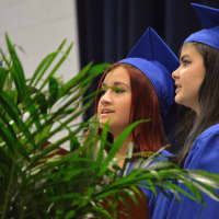 <p>Madeleine Diamond and Brittany Taylor welcome the crowd at the Abbott Tech High School graduation with a song.</p>
