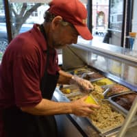 <p>Marc Silverberg scoops cookie dough in his shop on Rock Road.</p>