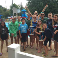 <p>Members of the Maywood Dolphins Swim Team and coaches pose with the league championship trophy.</p>