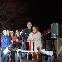 <p>Meg Greiner, Hendrick Hudson’s Athletic Trainer, switches on the Christmas tree at the Cortlandt Engine Company’s firehouse in Montrose as members of the high school musical group, The Treble Makers, look on.</p>