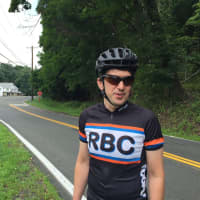 <p>Michael Benowitz, president of the Rockland Bicycling Club, stands on Greenbush Road in Blauvelt. A bike bypass connecting the northern and southern portions of Greenbush will be built behind him.</p>