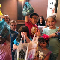<p>Several kids proudly display the candy they&#x27;re turning over, which will be shipped to soldiers overseas.</p>