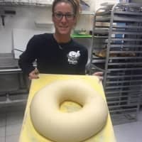 <p>Stephanie Evans of Our Town Bagels &amp; Bakery in Mahopac, displays a super-sized bagel destined to become a party sandwich.</p>