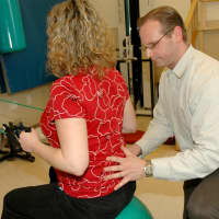 <p>Ben Gilbert, director of Outpatient Rehab Services at Burke Rehabilitation Hospital, helps one of his patients during a therapy session.</p>