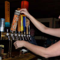 <p>Twisted Elm Bartender Colleen Miller pulls a Carton of Milk, a milk stout from Jersey-based Carton brewery. </p>