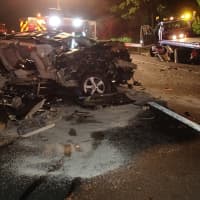 <p>An SUV is heavily damaged in a crash early Monday on I-95 in Westport. The flatbed tow truck is off to the right.</p>