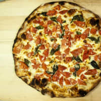 <p>Frank Pepe Pizzeria Napoletana Fresh Tomato Pie is back on the menu at the restaurants this summer.</p>