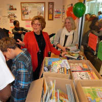 <p>Ann Spindel (red Jaket) helps to hand out books along with Westchester Community Foundation Executive Director Laura Rossi (white jacket).</p>