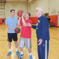 <p>Oliver works on improving his shots as his volunteer buddy and coach look on</p>