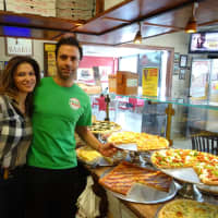 <p>Adisa Feratovic, left, helps her fiancé, Gaetano Buttitta, operate Pizza Mania in Garfield.</p>