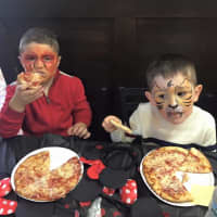<p>Painted faces AND pizza! Does life get better than that? Two young patrons of Pizza One in Haskell chow down on pies they made themselves.</p>