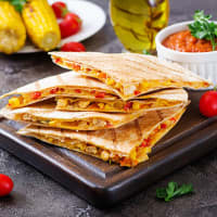 <p>A &quot;Sunrise Quesadilla&quot; with bacon, cheddar cheese, scrambled eggs and avocado sour cream</p>