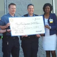 <p>Ramapo police officers hold a check for $1,000 from Walmart intended for the DARE program.</p>