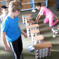 <p>Randolph School students work on a practice build of their structure.</p>
