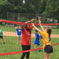 <p>Students give a double high-five during a field day at Riverside School.</p>