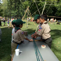 <p>Troop 53 Scouts teach a visitor how to make rope.</p>