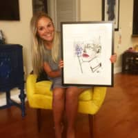 <p>Rebecca Russoholding one of her drawings.</p>