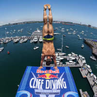 <p>Constantin Popovici of Romania prepares to dive from the 28 meter platform during final competition day at the Red Bull Cliff Diving World Series in Boston on June 4, 2022.</p>