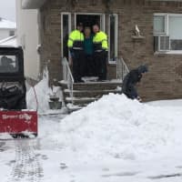 <p>Andrew Ralicki, 15, shovels snow in Saddle Brook for a senior citizen. The senior is flanked by Saddle Brook Police Chief Robert Kugler and Mayor Robert White.</p>