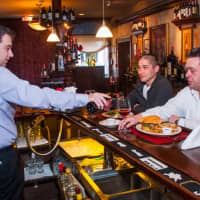 <p>Sapore Steakhouse&#x27;s general manager pours a little vino for two of the chefs at the Fishkill eatery.</p>