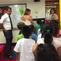 <p>K.T. Murphy Principal Frank Rodriguez looks on as students listen to teachers Chelsea Romaniello, center, and Catie Ramsey on the first day of school.</p>