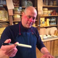 <p>Ken Skovron, co-owner of Darien Cheese &amp; Fine Foods, shows a core of traditional cheddar cheese. </p>