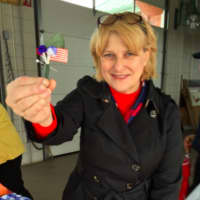 <p>Deborah Hein, a member of the Sarah Riggs Humphreys-Mary Silliman DAR chapter holds up a pin DAR members were giving to people who had attended a Veterans Day ceremony in Shelton on Wednesday.</p>