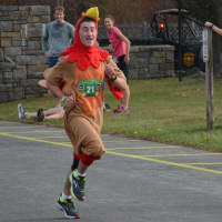 <p>Taking the Bedford Turkey Trot in a literal direction, Ben Baum heads towards in the finish line while running in a turkey costume.</p>