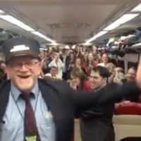 <p>Metro-North conductor Bob McDonough tries his hand at musical conducting as the Yale Glee Club rides his train last week.</p>