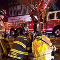 <p>City and volunteer firefighters work at the scene of a Christmas evening blaze on Main Street in Danbury.</p>