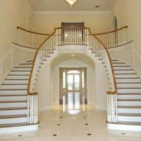 <p>A beautiful double staircase greets visitors upon entry to the home.</p>