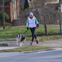 <p>Anne McDonnell takes a dog for a run in Ridgewood.</p>