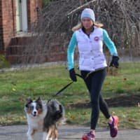 <p>Anne McDonnell takes a dog for a run in Ridgewood.</p>
