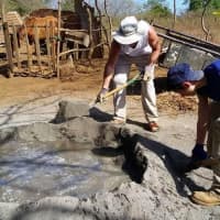 <p>Students, seen here pouring mixed concrete, build foundations for the villagers&#x27; homes.</p>