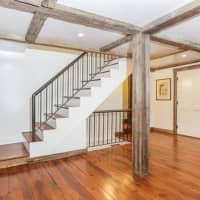 <p>Wide-plan hardwood floors and open beam construction takes the house back to its original construction.</p>