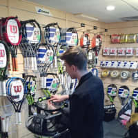 <p>Colin Athens re-strings a racket at the newly designed pro shop at Saw Mill Club.</p>
