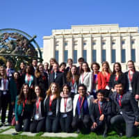 <p>Members of a committee including both Pace and non-Pace students pose in front of the Palais des Nations.</p>