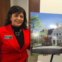 <p>Ridgefield Visiting Nurse Association President and CEO Theresa Santoro standing beside a rendering of the RVNA&#x27;s new facility.</p>