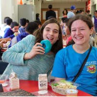 <p>Two girls eating blue donuts to show their support for World Autism Day</p>