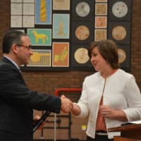 <p>Dr. Christopher Manno shakes hands with Bedford Central school board President Jennifer Gerken after the board voted to appoint him as schools superintendent.</p>