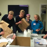<p>Volunteers prepping grocery bags for a U.S. Postal Service food drive at Person to Person during Kyle A. Markes Day of Service April 16.</p>