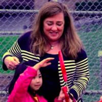 <p>Mayor Diane Didio helps a young Oradell resident cut the ribbon on Hoffman Field Saturday.</p>