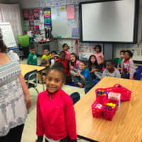 <p>Cianna Gaston, 6, along with her first grade teacher Janet Inzitari with her fellow students, participates in the &quot;Business to Books&quot; read-a-thon at Toquam Magnet School. NBCUniversal staff came in to read to the students.</p>