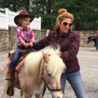 <p>Round Hill Nursery School student Grace O&#x27;Sullivan, 3, rides, Hunny, 16, a Shetland Pony mix during Western Day at the school Friday. Also pictured is Jessica Pavella, who is guiding the pony.</p>